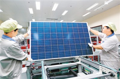 江蘇連云港神舟新能源有限公司工人在太陽能光伏生產線上忙碌。