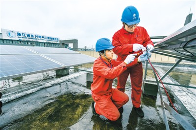 浙江省長興縣湖州昆侖電氣設備有限公司工作人員檢查分布式光伏電站設備運行情況。